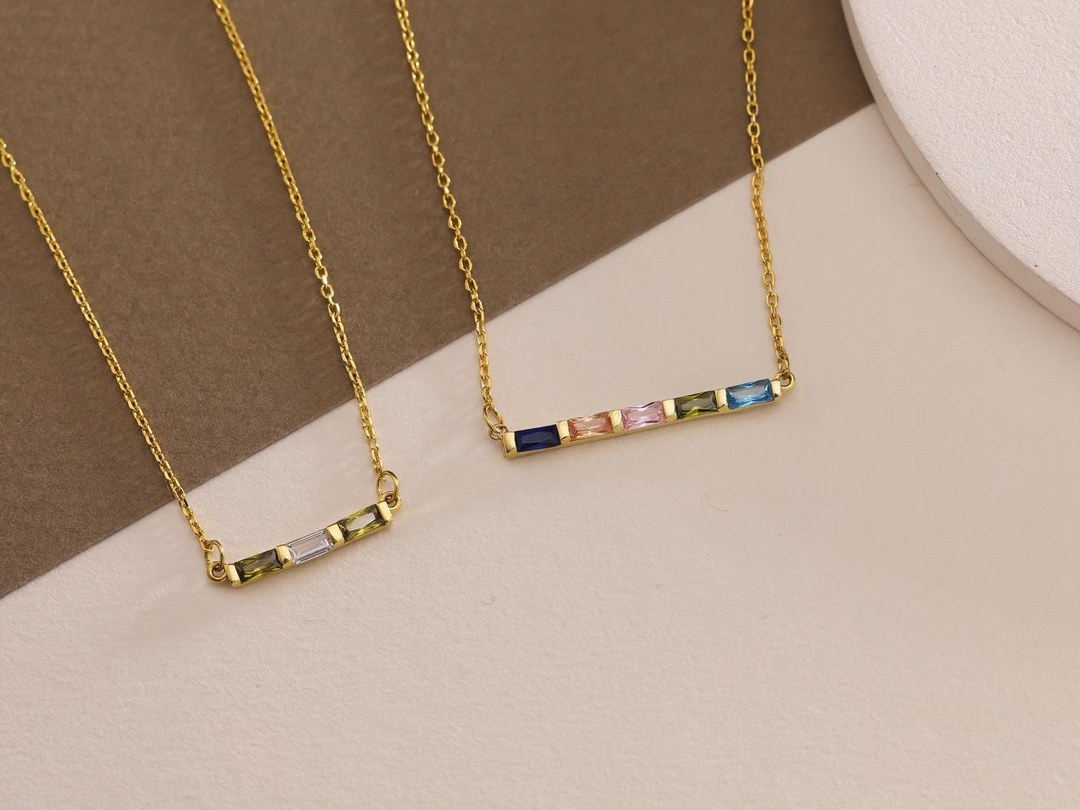 Divanjewelrygold baguette-cut family birthstones set in a clean row on a gold bar