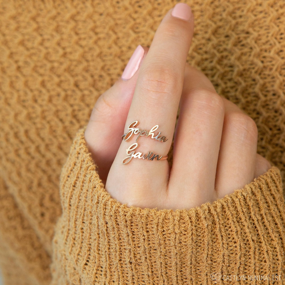 Sterling silver wrap ring engraved with two names, worn on a hand