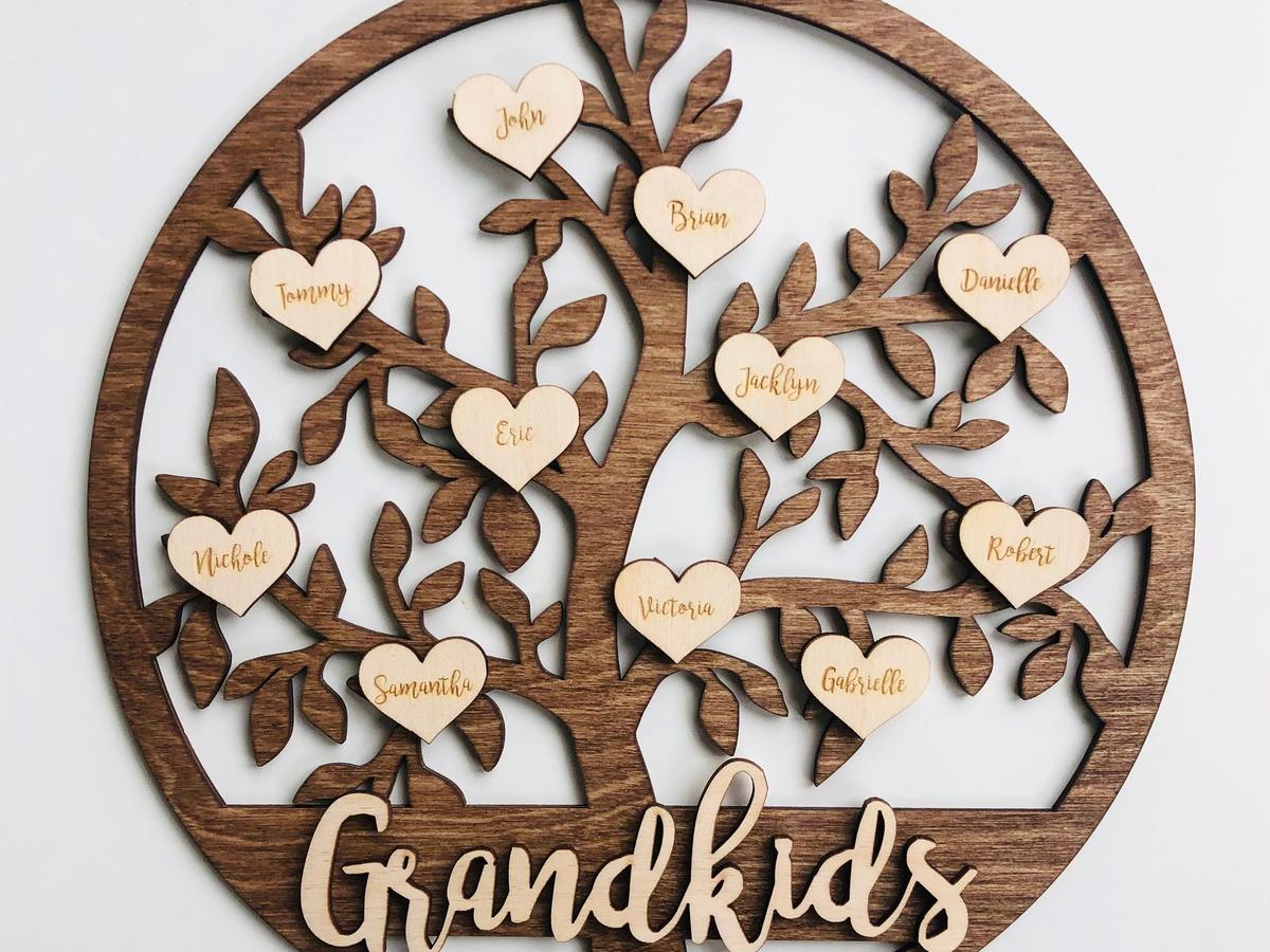 Round laser-cut dark wood family tree with a pale wooden heart engraved with each grandchild's name