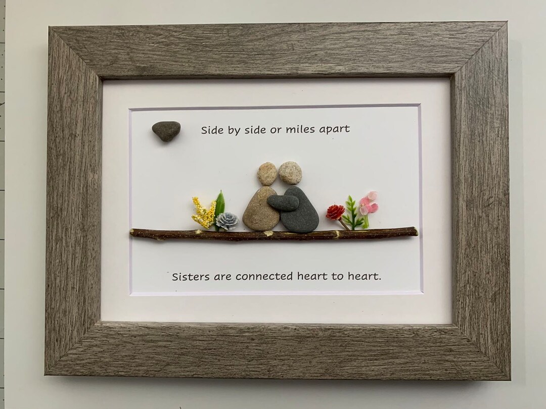 Framed pebble art of two figures with a personalized sister quote, a sentimental Christmas gift