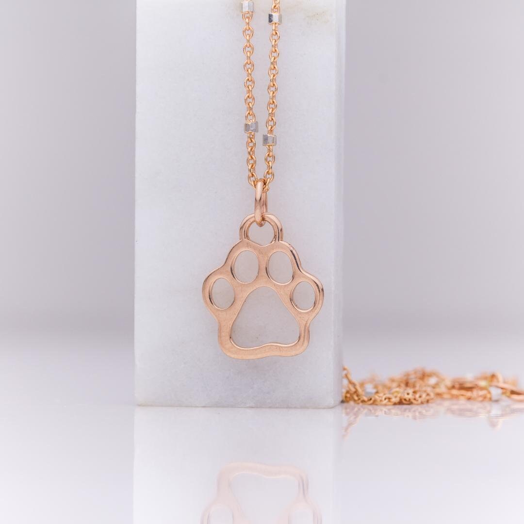 Solid 14k rose gold paw print pendant on a fine chain
