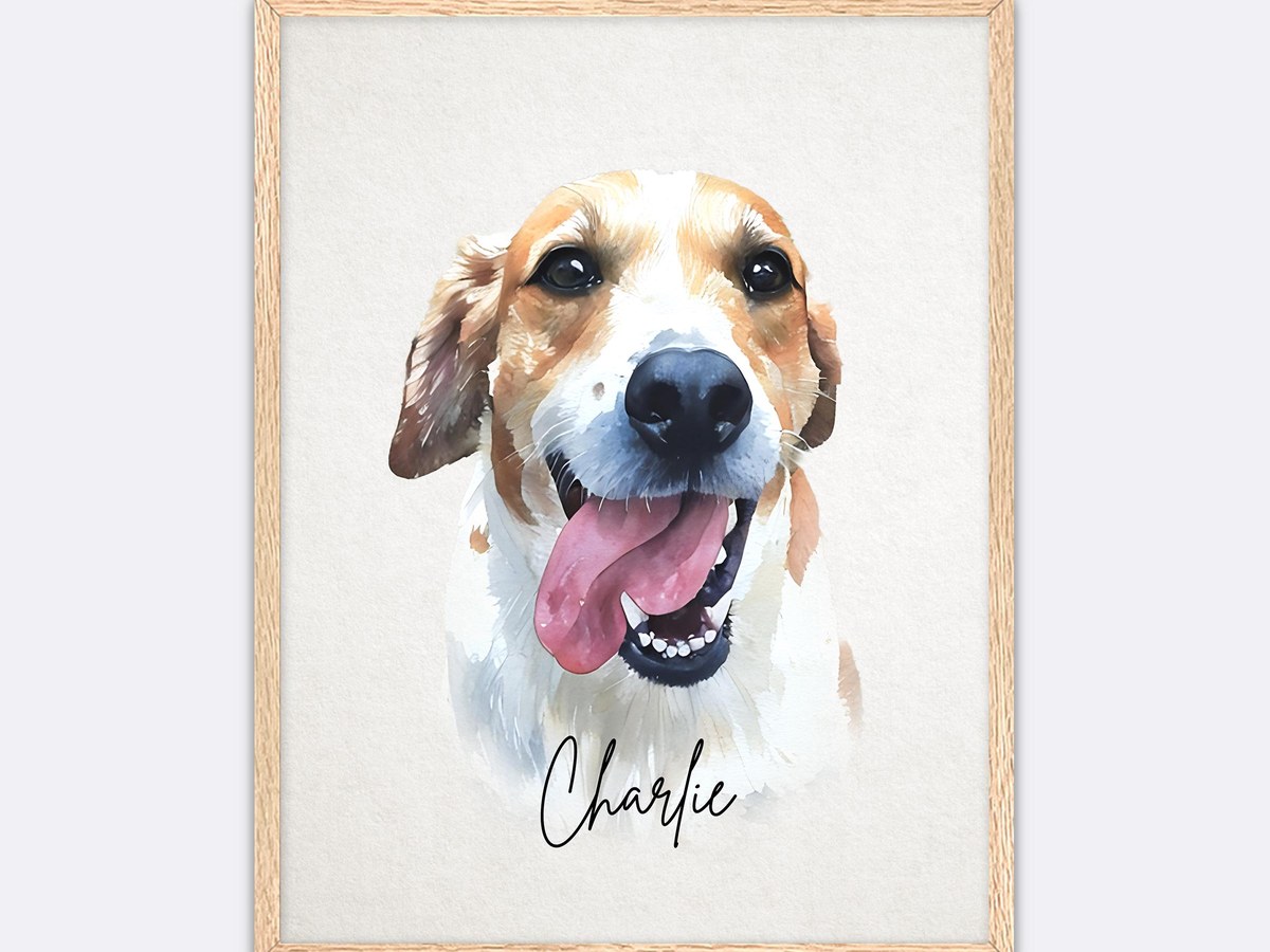 Watercolor portrait of a happy dog with its tongue out and a name written beneath, in a light wood frame
