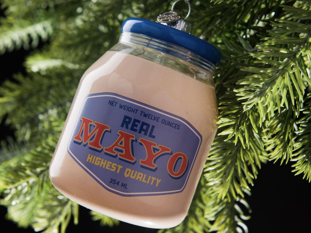 Glass Christmas ornament shaped like a jar of mayo with a blue and red retro label, hanging on a tree
