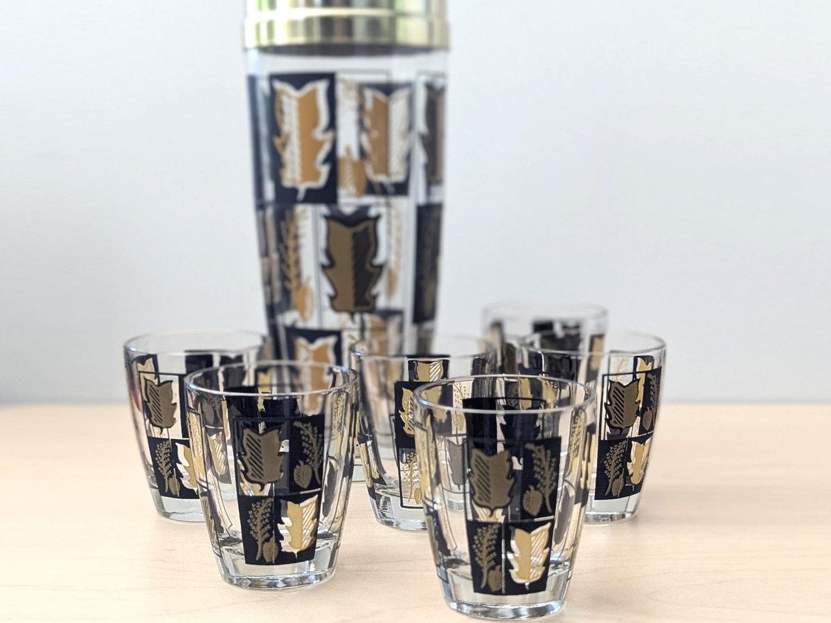 Vintage 1960s glass cocktail shaker with black and gold leaf pattern and six matching glasses, mid century barware set